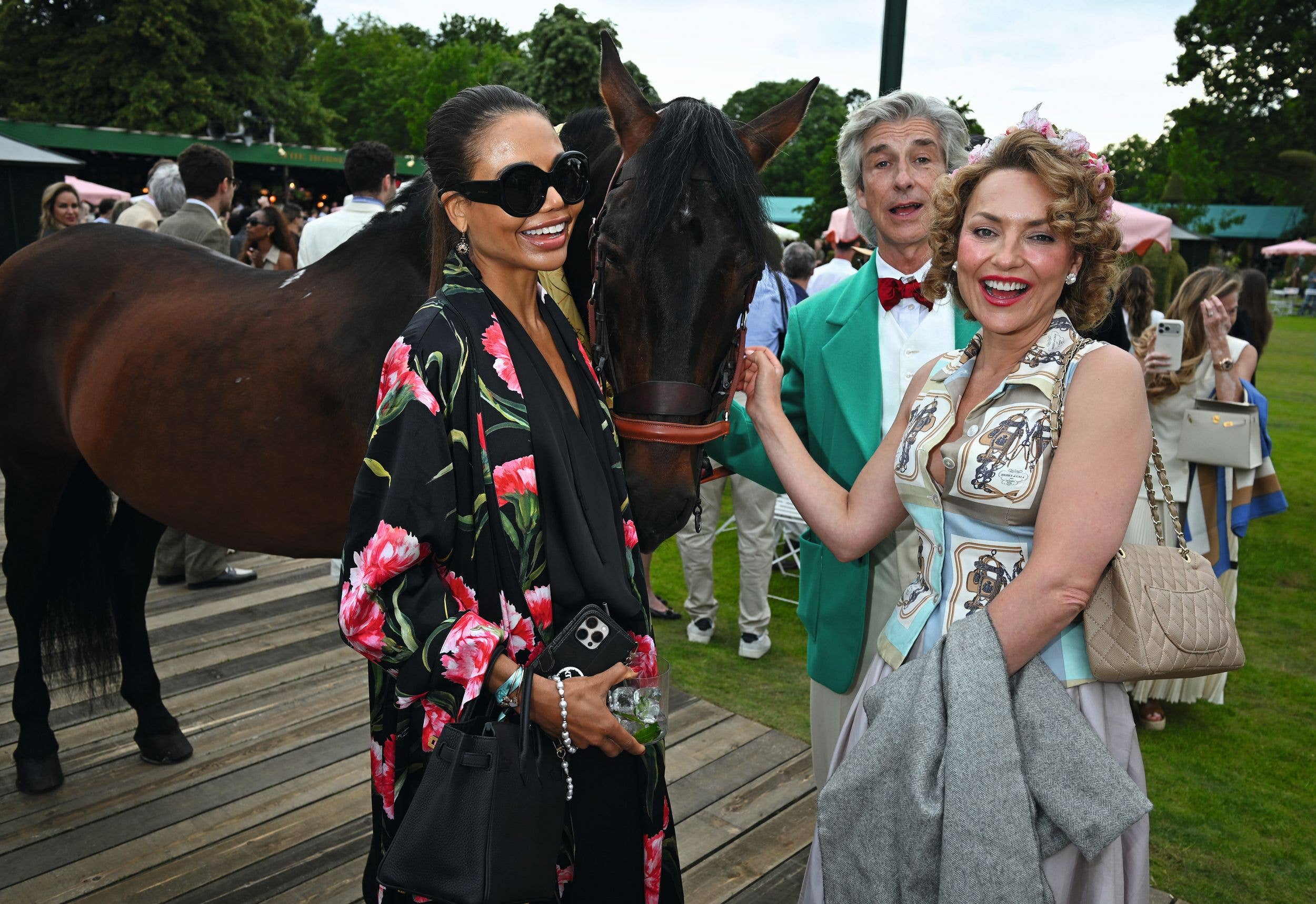 Emma Thynn, Marchioness of Bath, and Lady Martha Sitwell pet a horse at the Garden Cocktail event celebrating the Opening of Maison Hermes New Bond Street store at The Hurlingham Club
