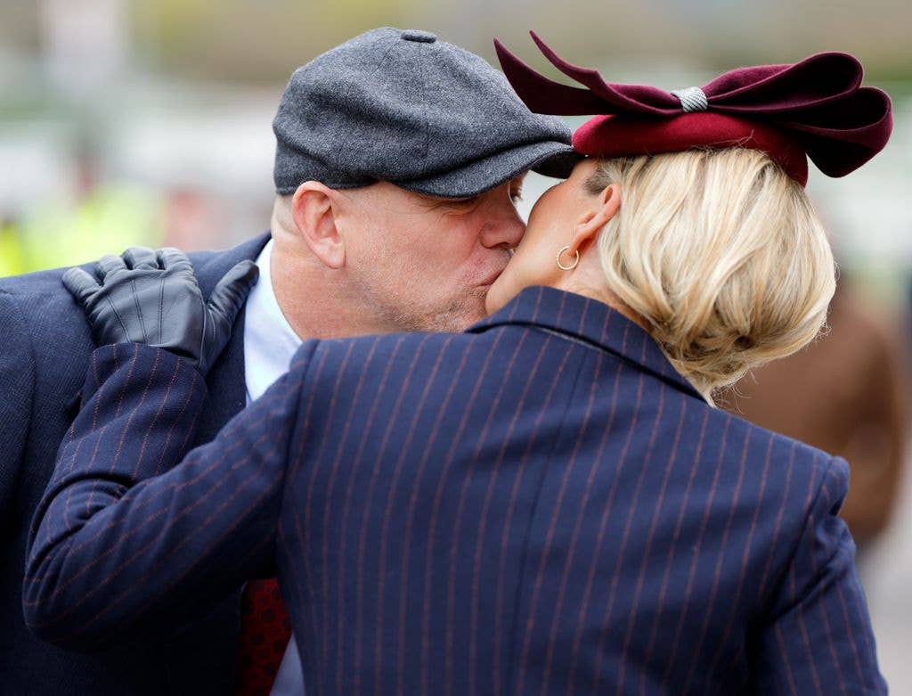 Mike Tindall kisses wife Zara Tindall as they attend day 2 'Style Wednesday' of the Cheltenham Festival at Cheltenham Racecourse on March 13, 2024