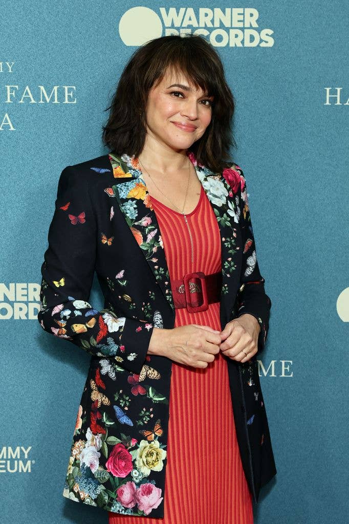 Norah Jones in a red stripy belted dress and black jacket with a colourful floral print in 2026 at the Grammy Hall of Fame Gala.
