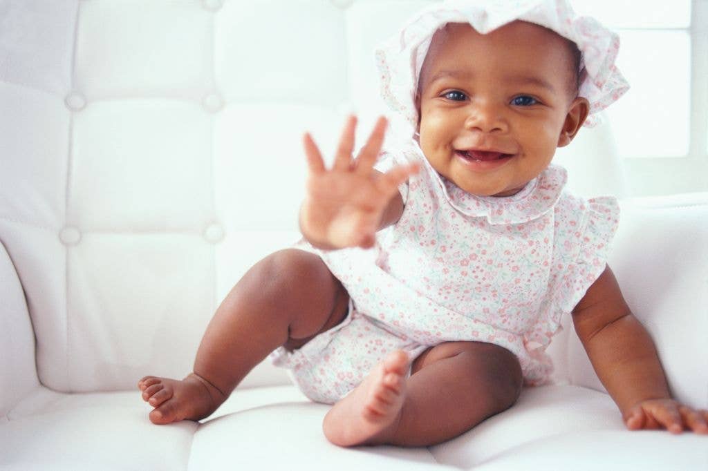 Baby girl (9-12 months) reaching out