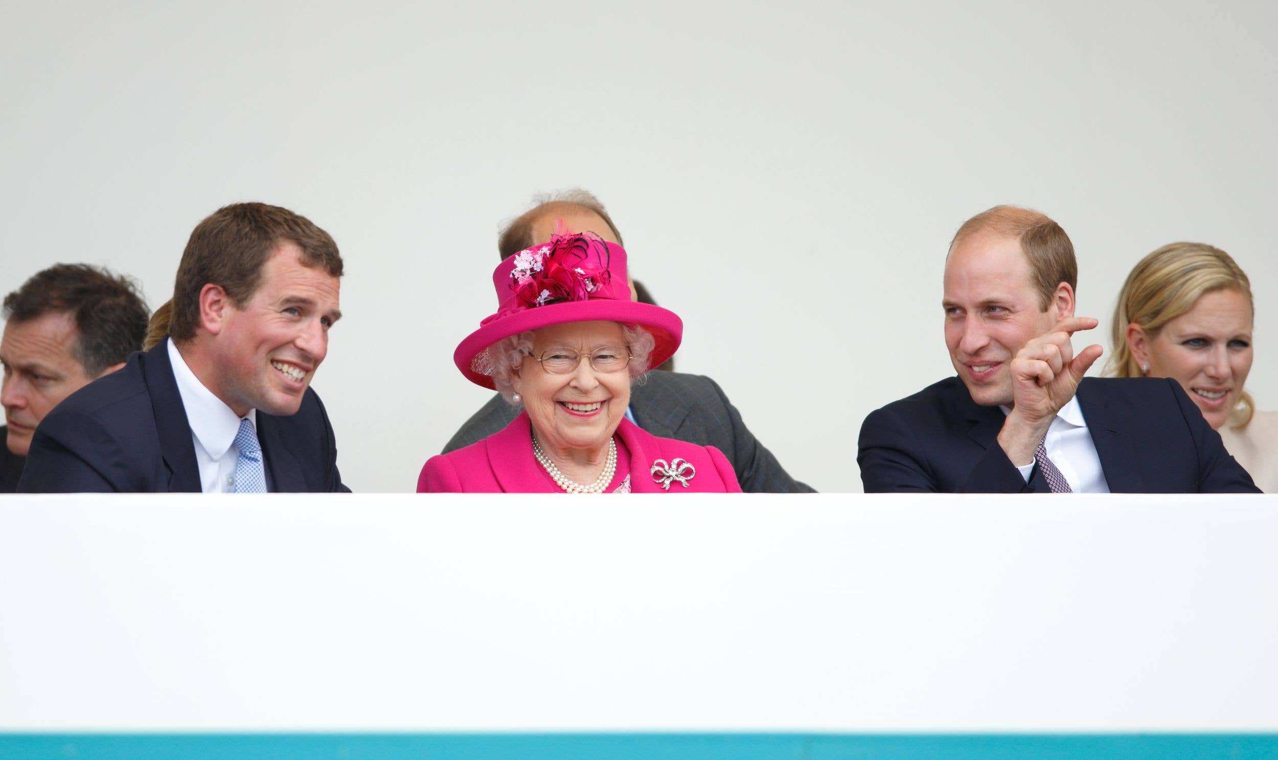 Peter Phillips, Queen Elizabeth II and Prince William watch a carnival parade as they attend 'The Patron's Lunch' celebrations to mark Queen Elizabeth II's 90th birthday on The Mall on June 12, 2016
