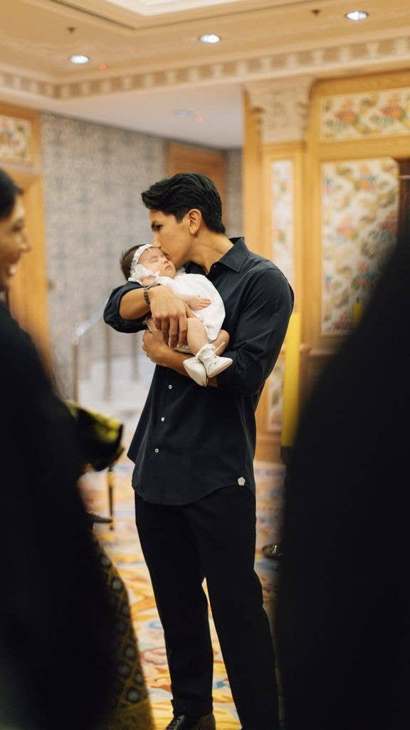 Prince Mateen kissing his daughter, Princess Zahra, on head holding her