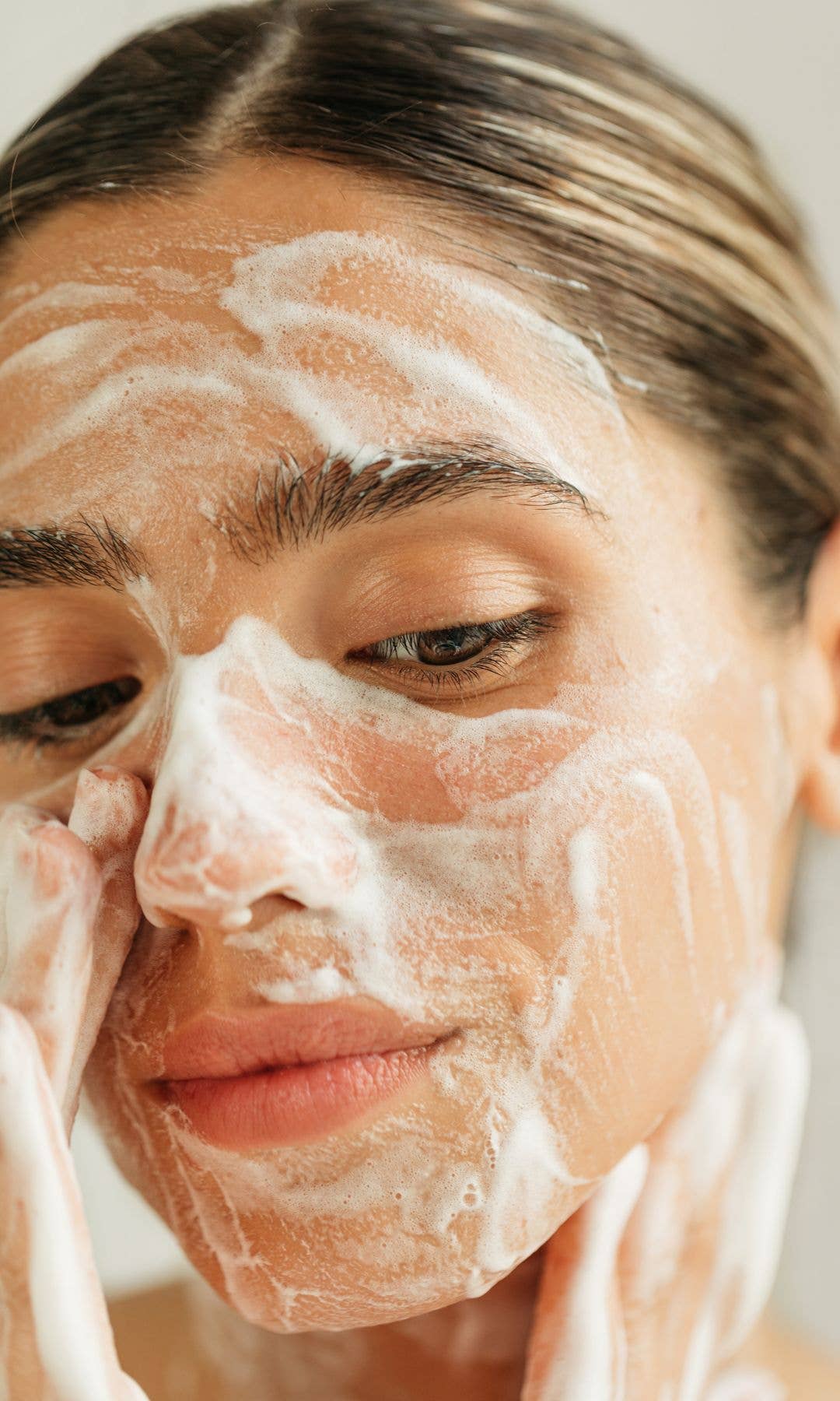 Model with a foaming cleanser on her face