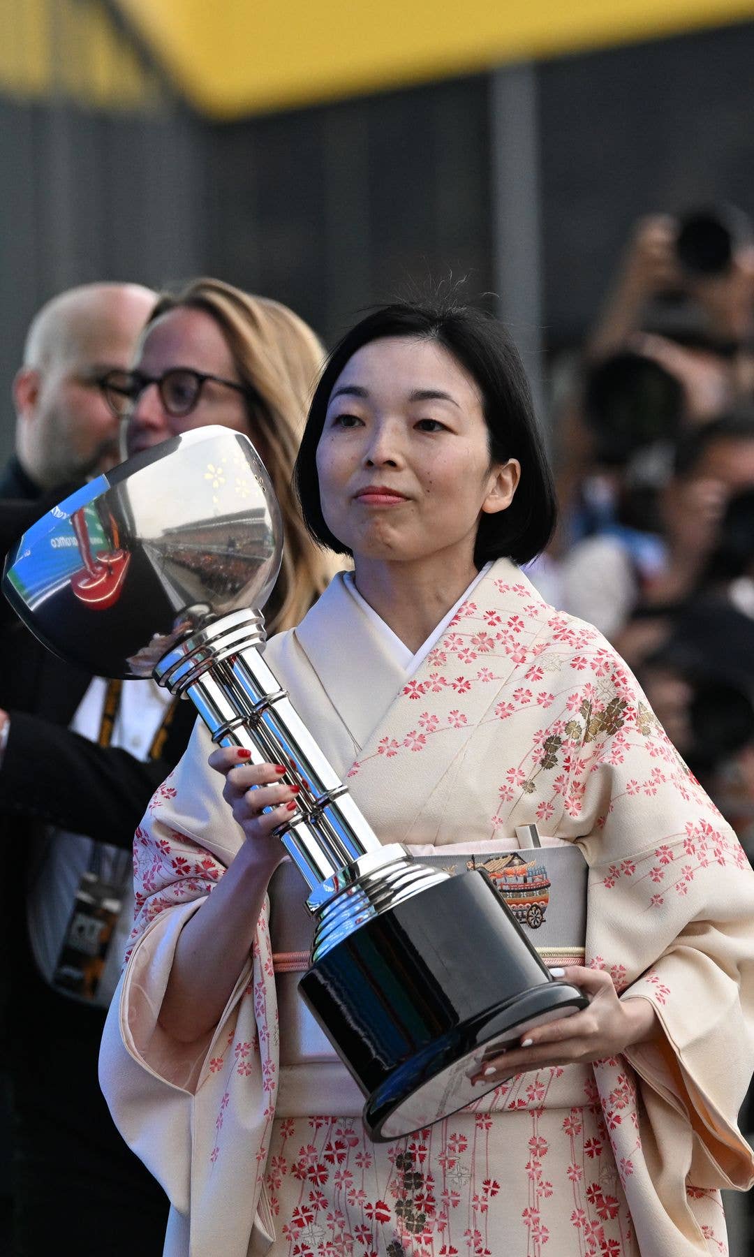 Princess Akiko walking with a trophy