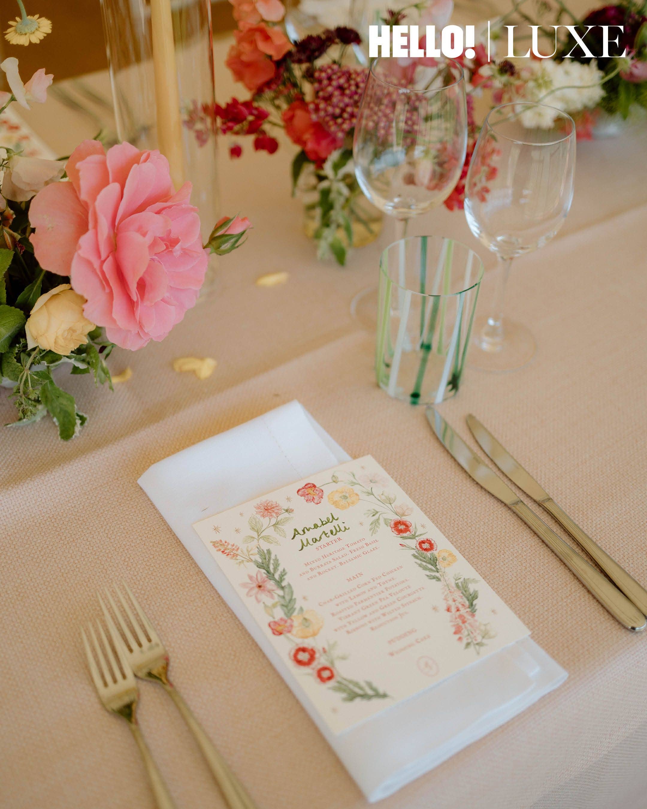 Set against pale pink table linens, each guest's place setting features a custom menu card detailing the wedding breakfast - which began with a mixed heritage tomato and burrata salad