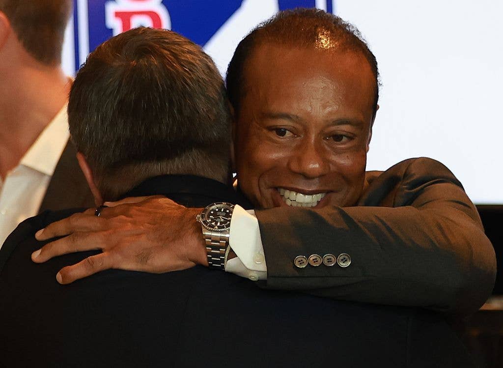 Tiger Woods of the United States embraces Brian Rolapp as it is announced Rolapp will become the next commissioner of the PGA TOUR effective Jan. 1 2027 during a Press Conference with PGA TOUR CEO Brian Rolapp prior to the Travelers Championship 2026 at TPC River Highlands on June 23, 2026 in Cromwell, Connecticut.