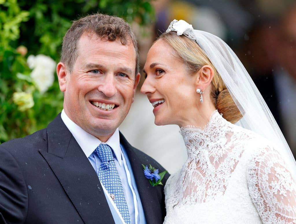 Peter Phillips and Harriet Sperling in wedding attire smiling, man in suit and tie, woman in lace gown and veil.
