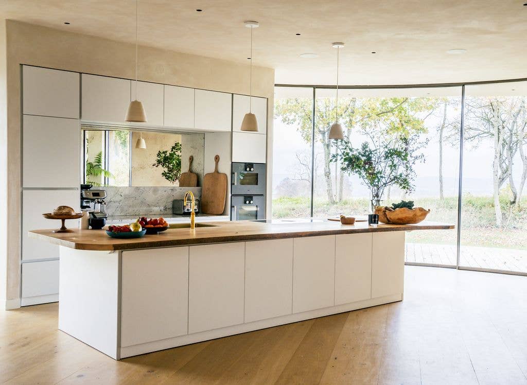 The kitchen features an oak worktop and a marble splashback in their Cotswolds Leaf House