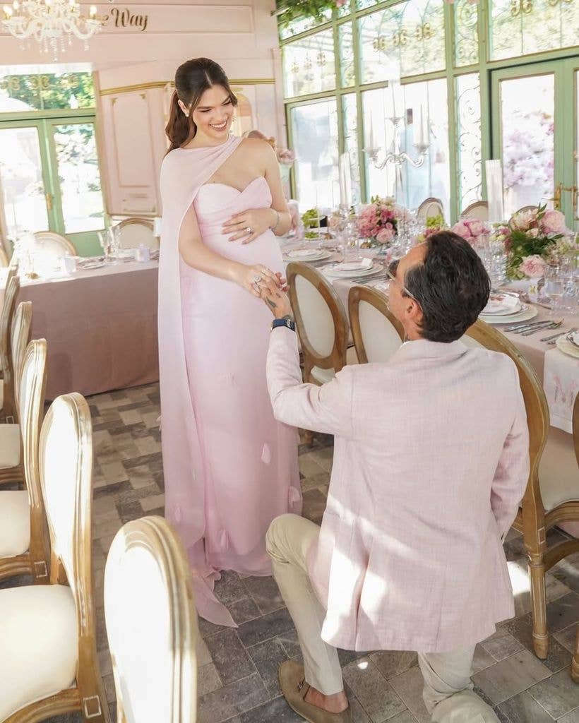 Marc kneels before Nadia, creating an intimate romantic scene