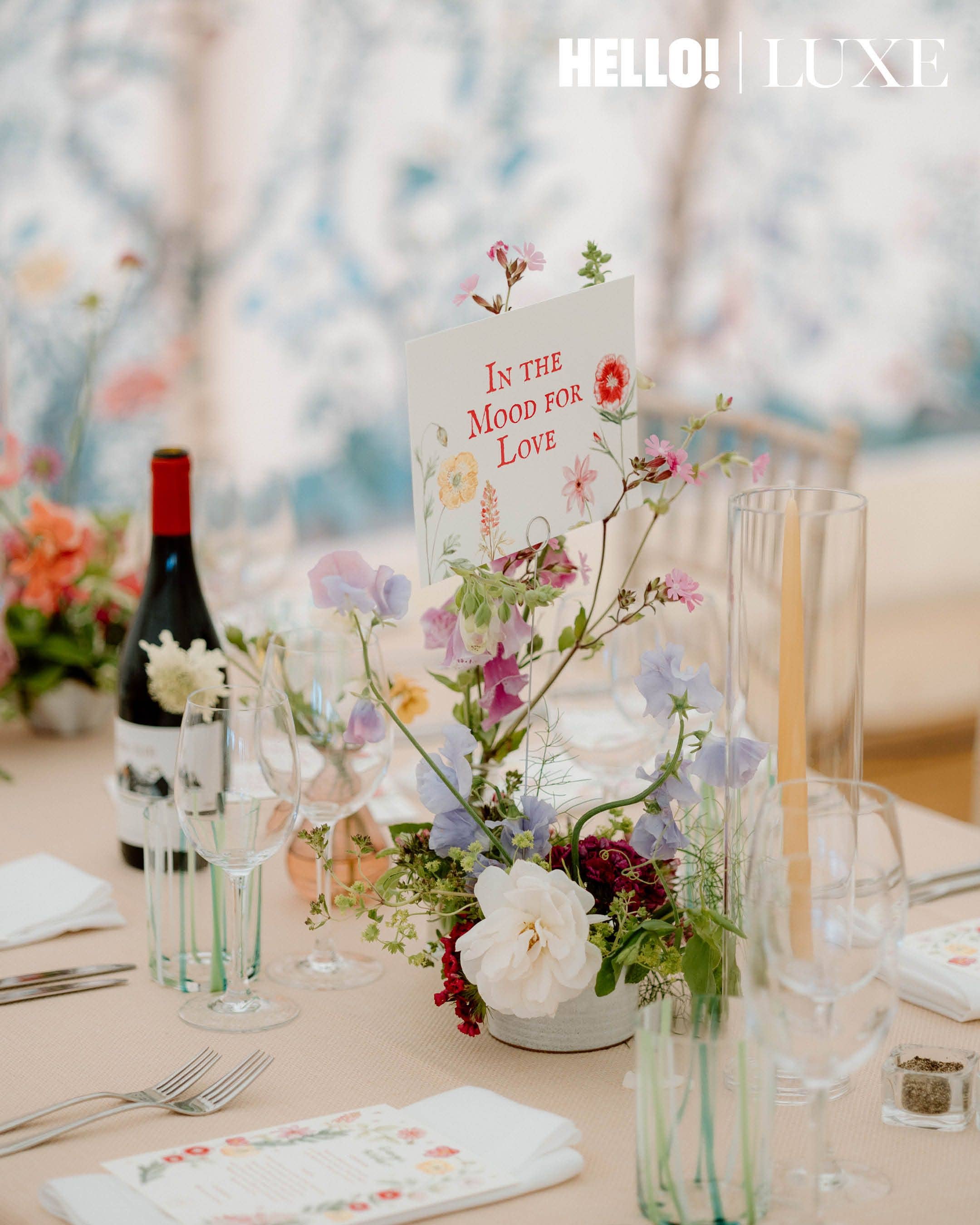 Another table setting highlighting a film-themed centerpiece card for In the Mood for Love, surrounded by sweet peas and tapered candles