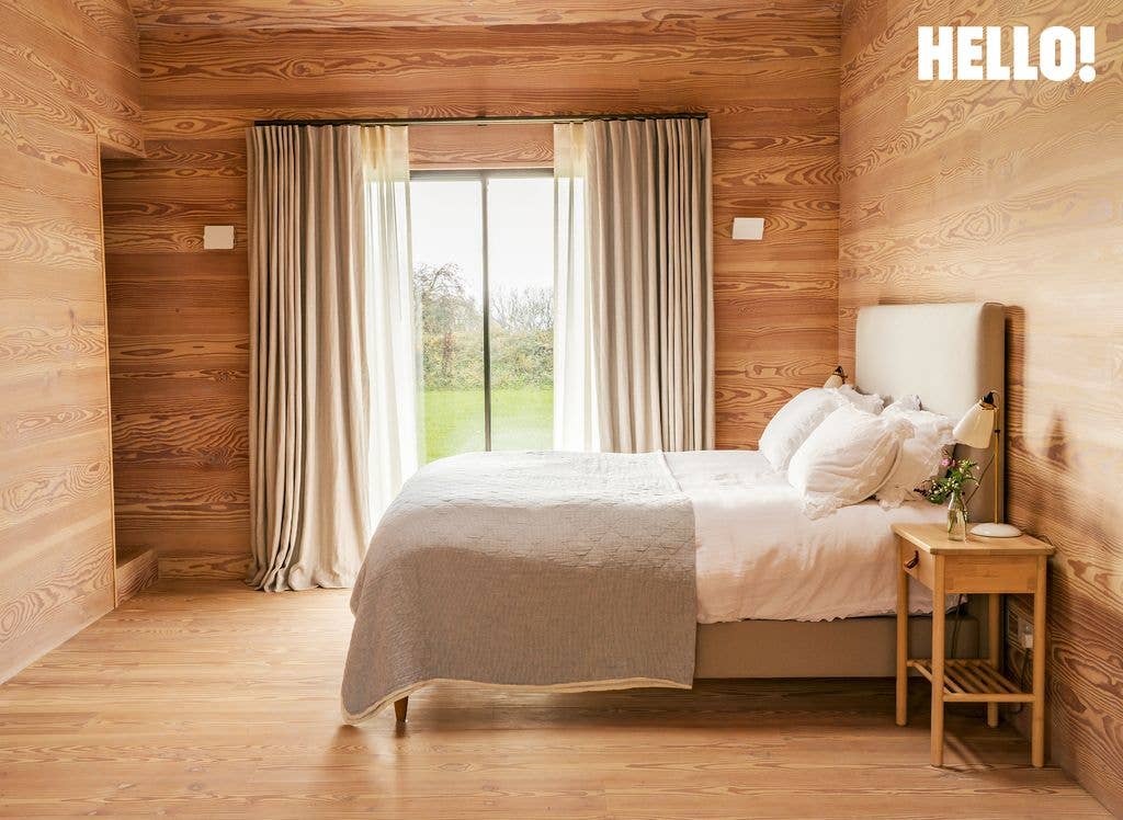 The main bedroom which has clay-plaster walls in their Cotswolds Leaf House