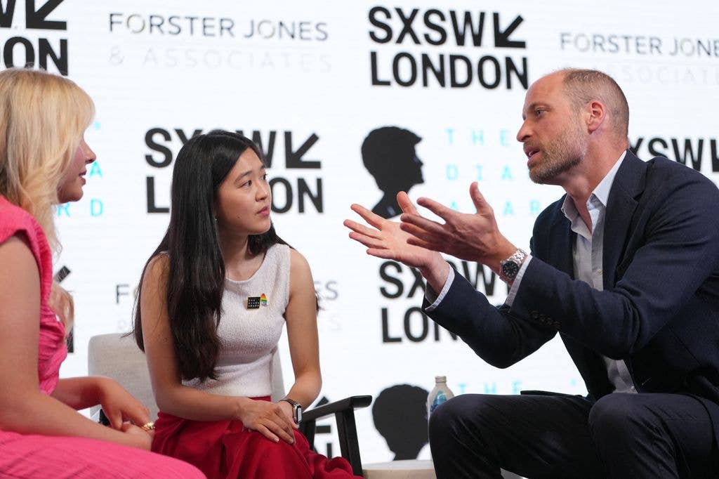 Britain's Prince William, Prince of Wales speaks to two winners of the Diana Award, Sophie Pender and Vivi Lin (C) at The Diana Award charity during the SXSW (South by Southwest) , in Shoreditch, east London on June 3, 2026. (Photo by Kin CHEUNG / POOL / AFP via Getty Images)