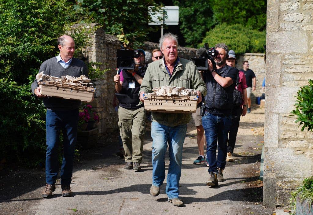 Jeremy Clarkson carrying mushrooms at the opening of his new pub, The Farmer's Dog