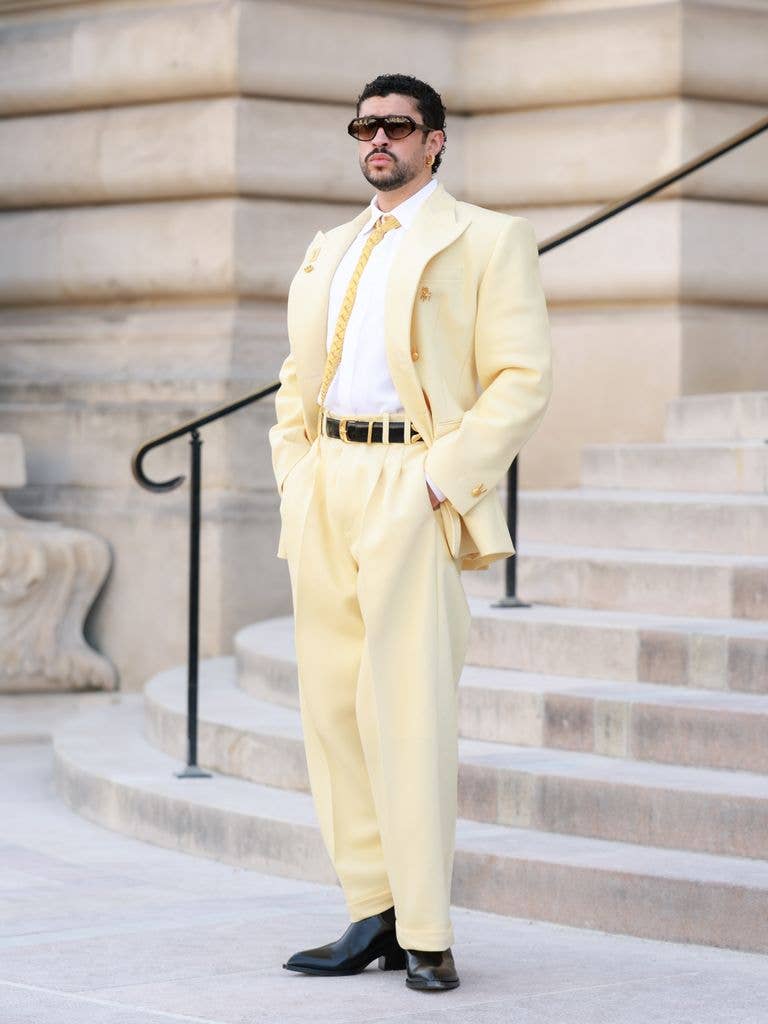 Bad Bunny wears a lemon yellow suit with white shirt and black shoes
