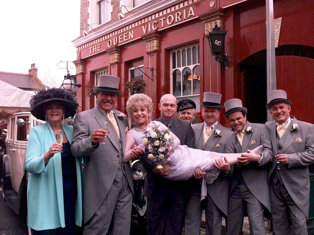 EastEnders stars Barbara Windsor (Peggy Mitchell) and Mike Reid (Frank Butcher 2nd left), with co-stars during a photocall outside the Queen Vic pub at London's Elstree studios, where their on-screen wedding reception was filmed.   * The bride and groom were joined by fellow actors (L/R) Pam St Clement (Pat), Ross Kemp (Grant), Steve McFadden (Phil), Shaun Williamson (Barry), and Tony Caunter (Roy).   (Photo by John Stillwell - PA Images/PA Images via Getty Images)