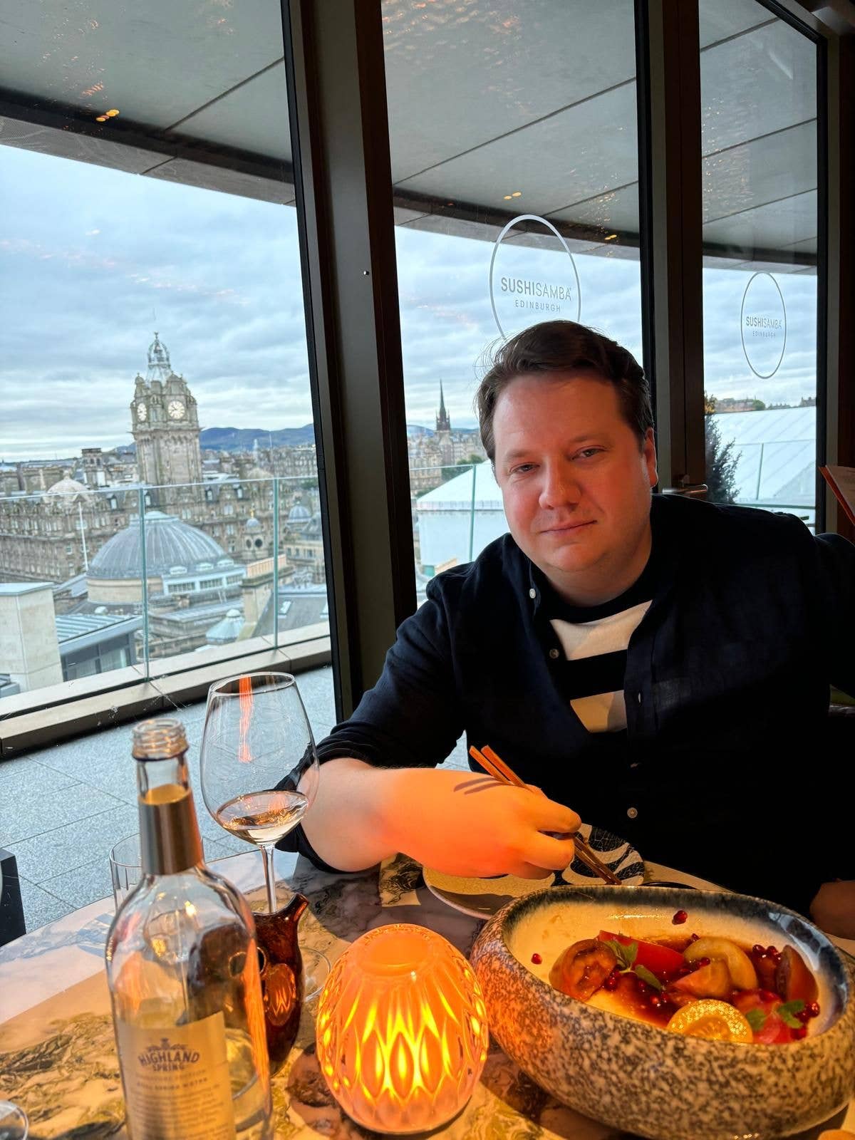 man eating sushi in edinburgh smiling 