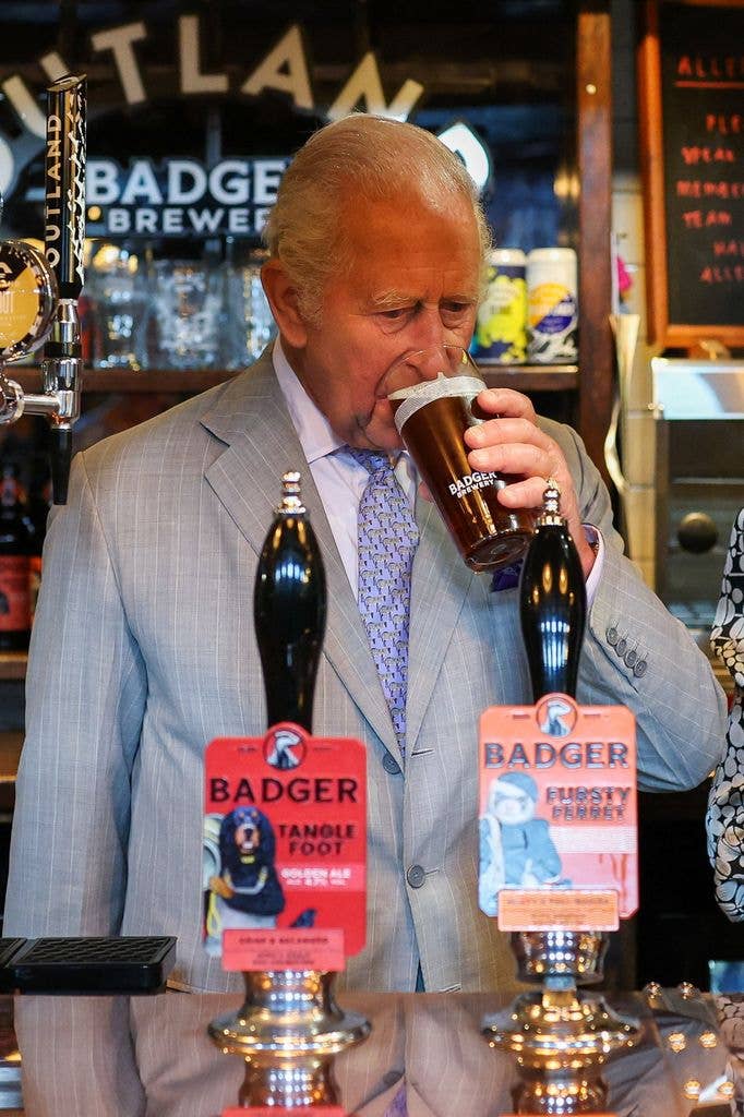 King Charles drinks a pint in the Hall and Woodhouse Badger Brewery bar
