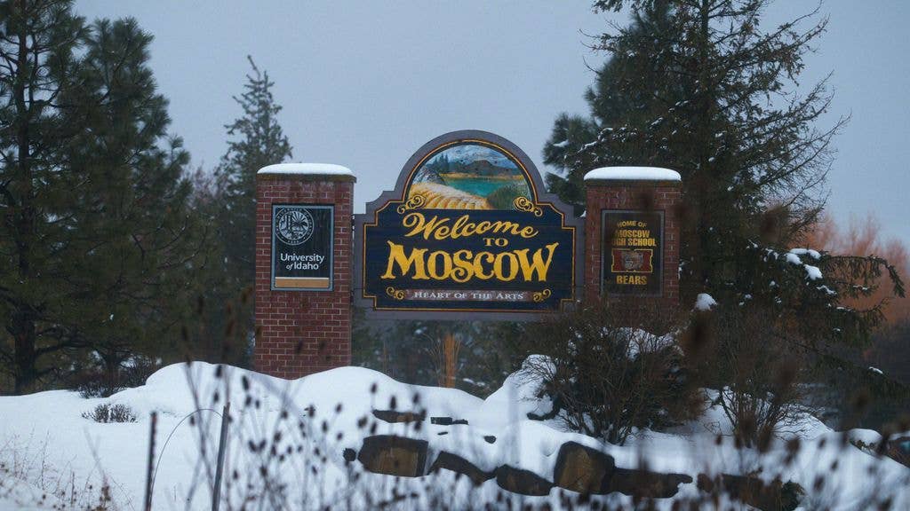 Snowy landscape with a 'Welcome to Moscow' sign, no celebrities detected.