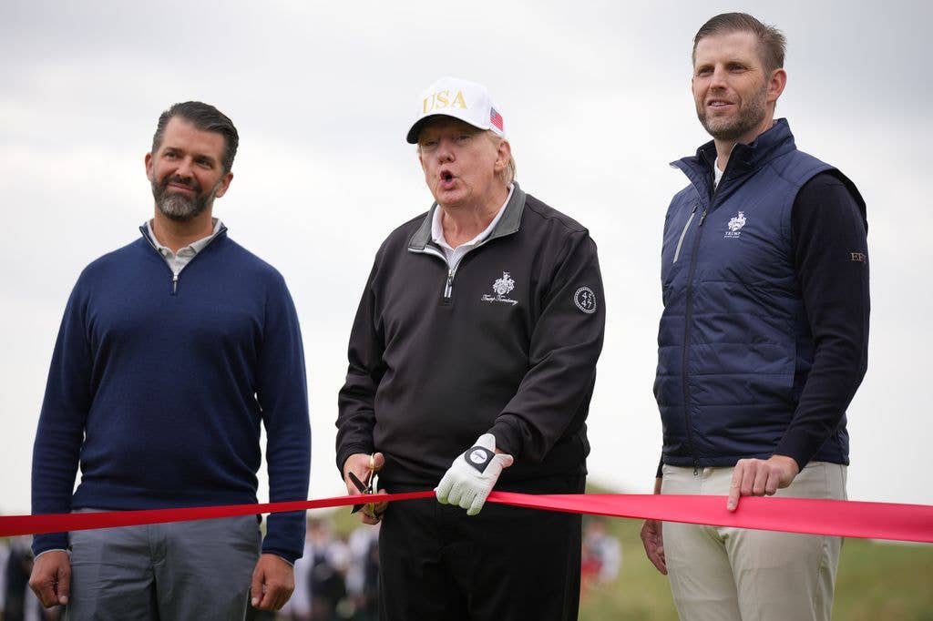 Donald Trump speaks next to Donald Trump Jr. (L) and Eric Trump as they attend the ribbon-cutting ceremony at a new 18-hole course at Trump International Golf Links on July 29, 2025