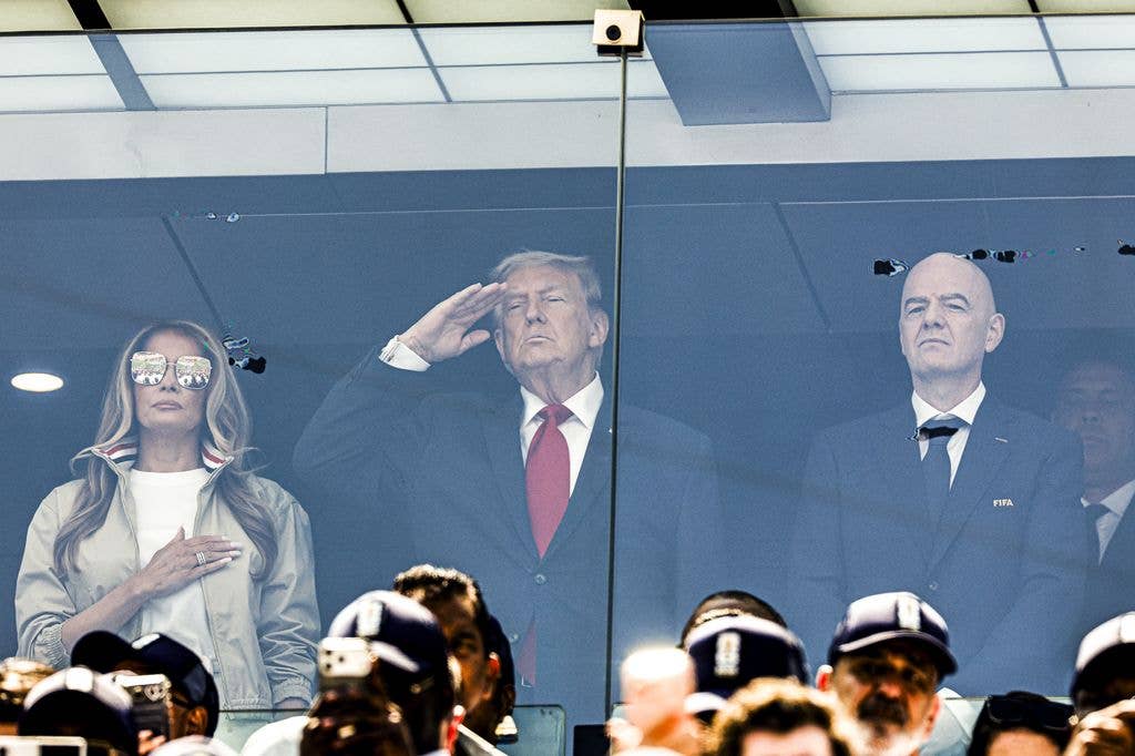 Melania stood with her hand over her heart, while the President saluted as the anthem played inside the packed stadium