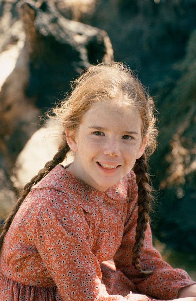 Melissa Gilbert as Laura Ingalls Wilder in a pink dress with two braids.