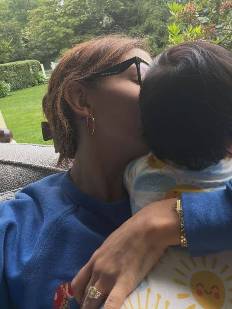 photo of millie bobby brown kissing baby daughter on the cheek