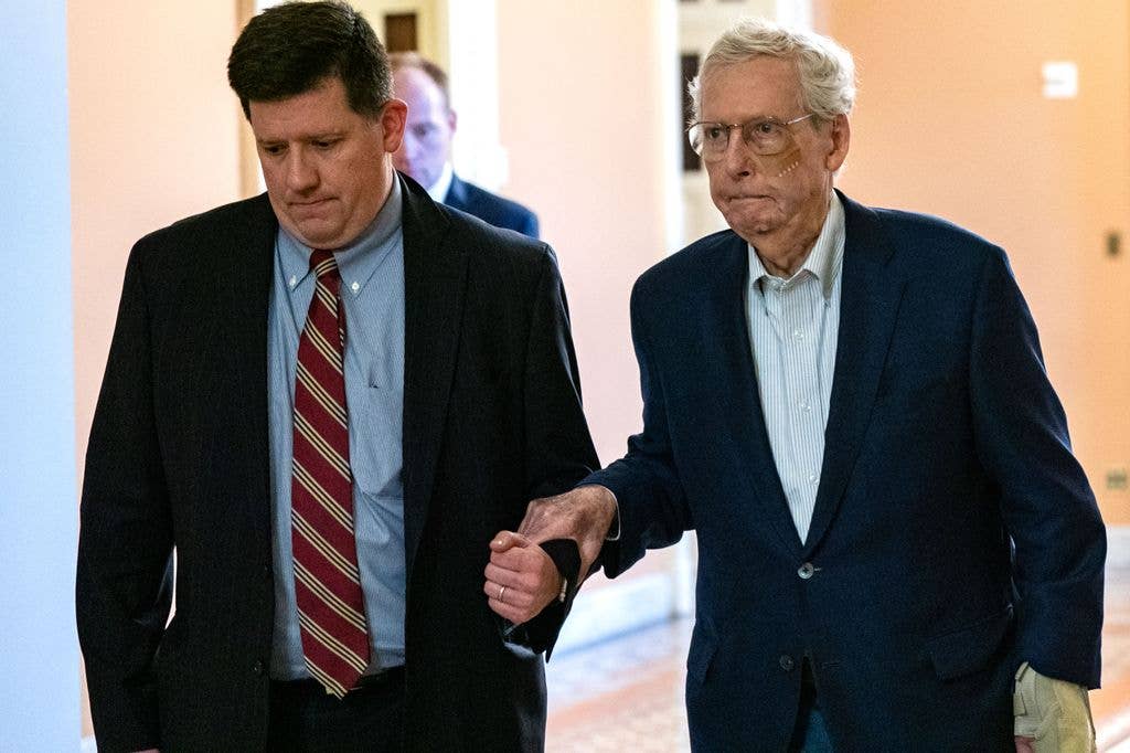 Mitch McConnell (R-KY) is assisted by staff as he goes to the Senate Chamber