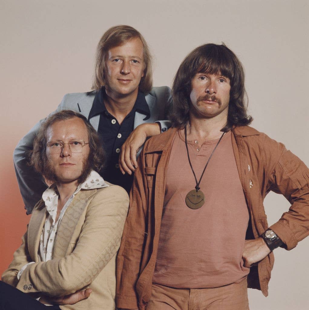 Three men, Tim Brooke-Taylor, Graeme Garden, and Bill Oddie, pose together in vintage attire.