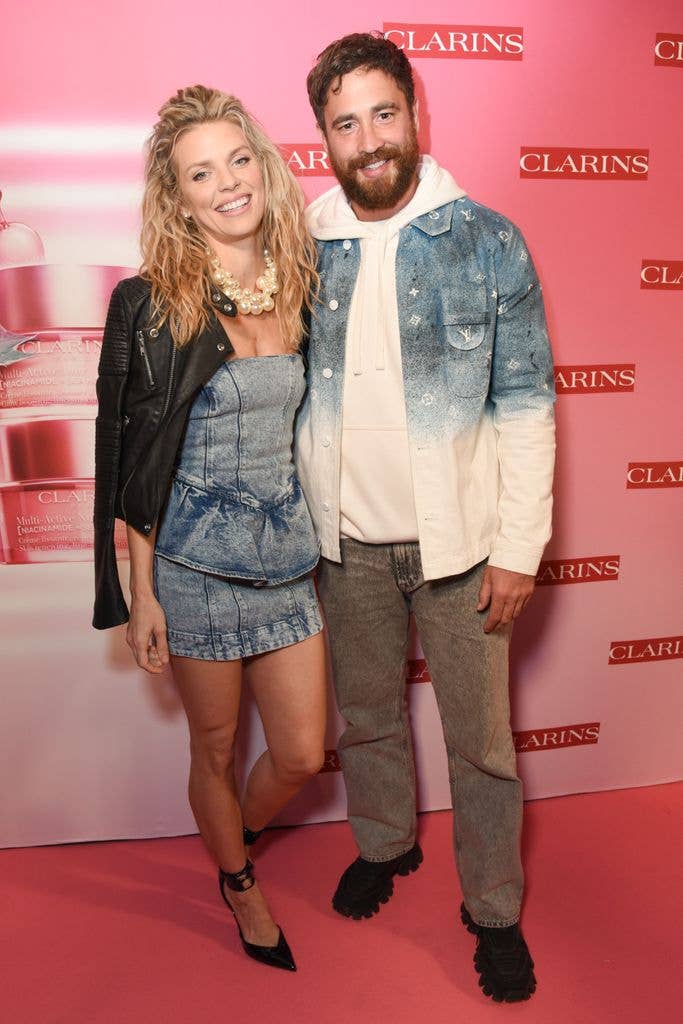 Danny Cipriani and AnnaLynne McCord standing together at a Clarins event, smiling.