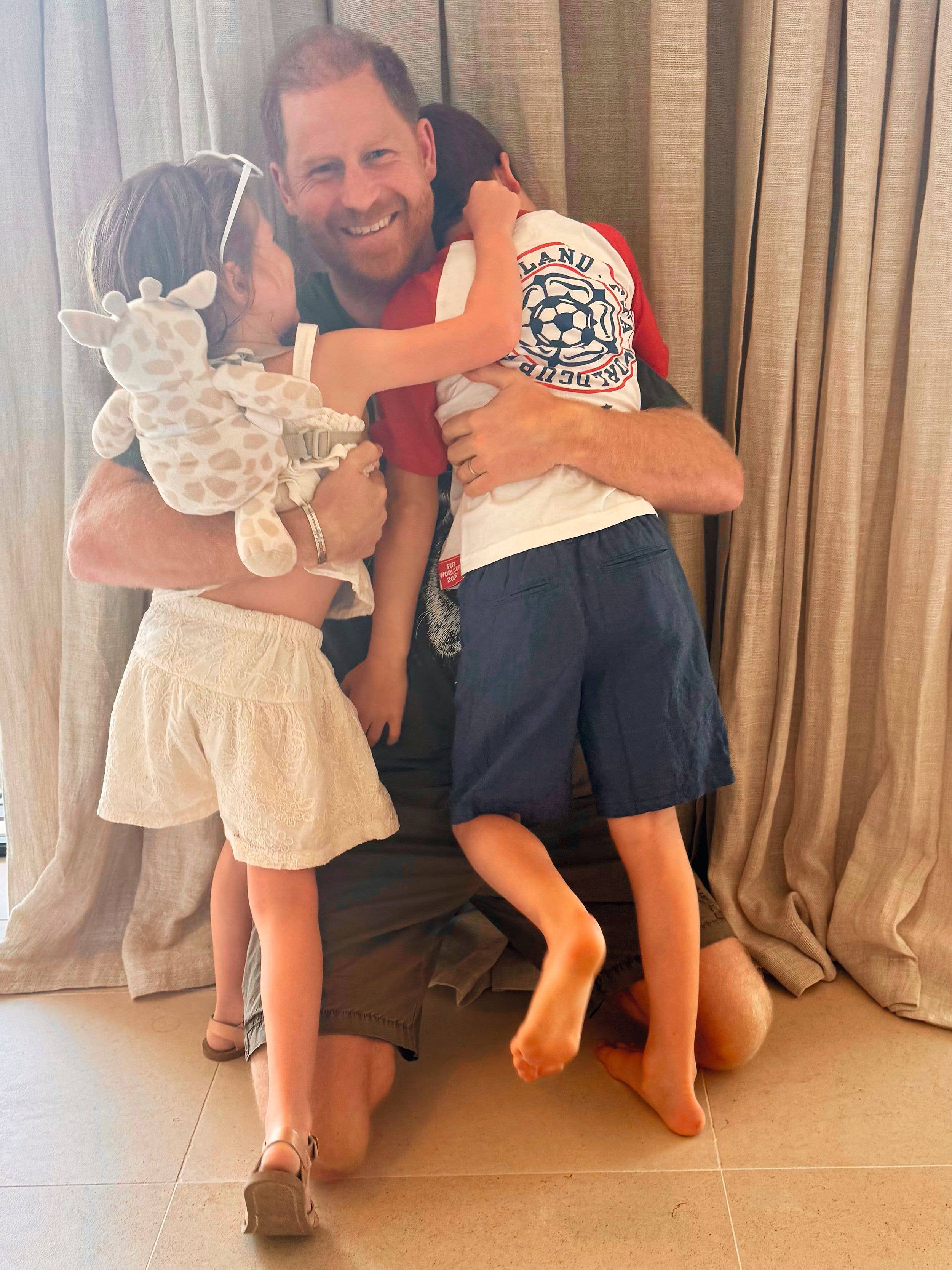 Prince Harry hugs Prince Archie and Princess Lilibet at home in California