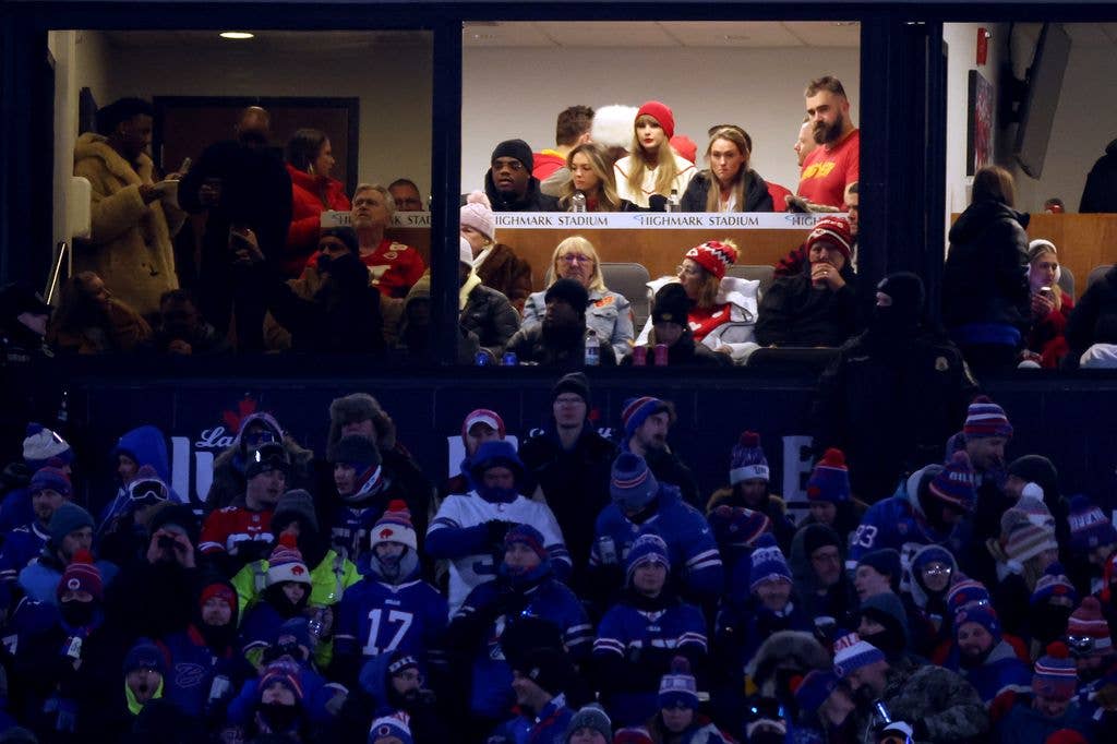 Singer-songwriter Taylor Swift (red hat C) sits with Jason Kelce (R) and Kylie Kelce (2R) 