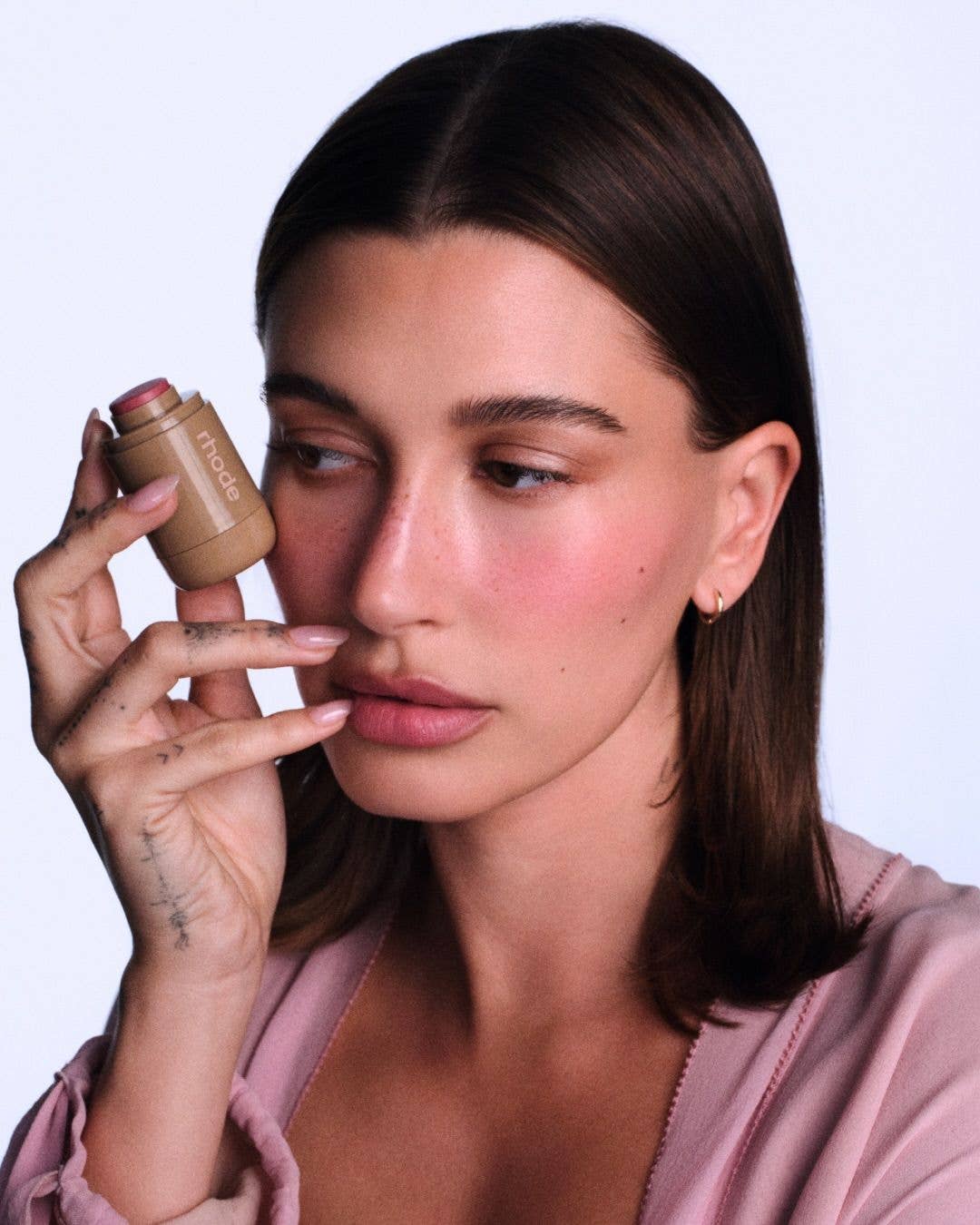 Hailey Bieber holding a rhode beauty blush 
