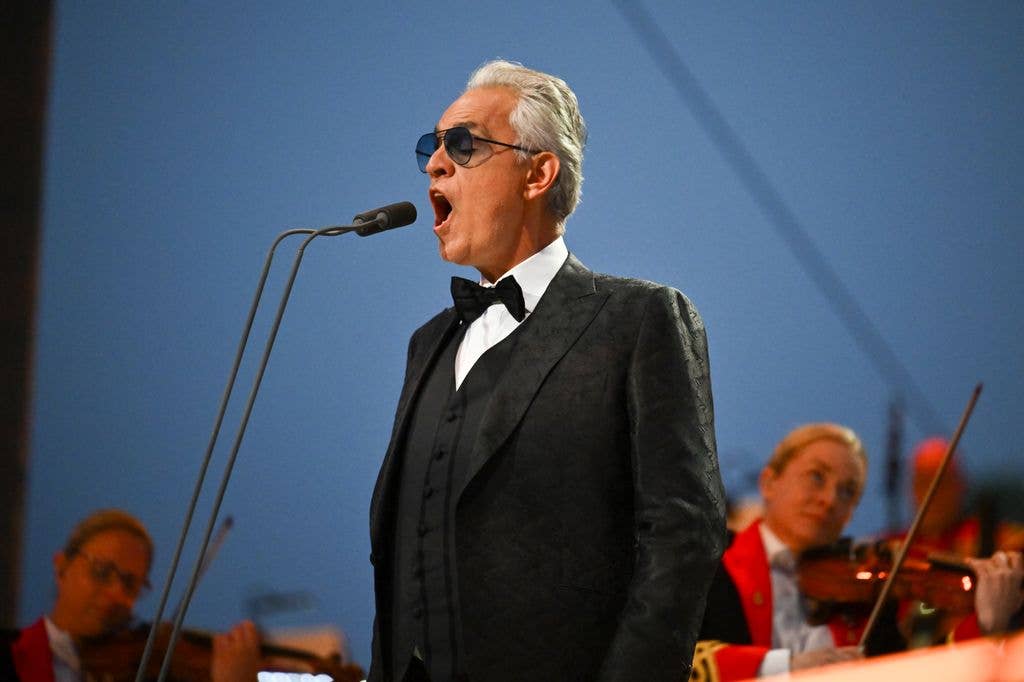 Andrea Bocelli singing in black suit