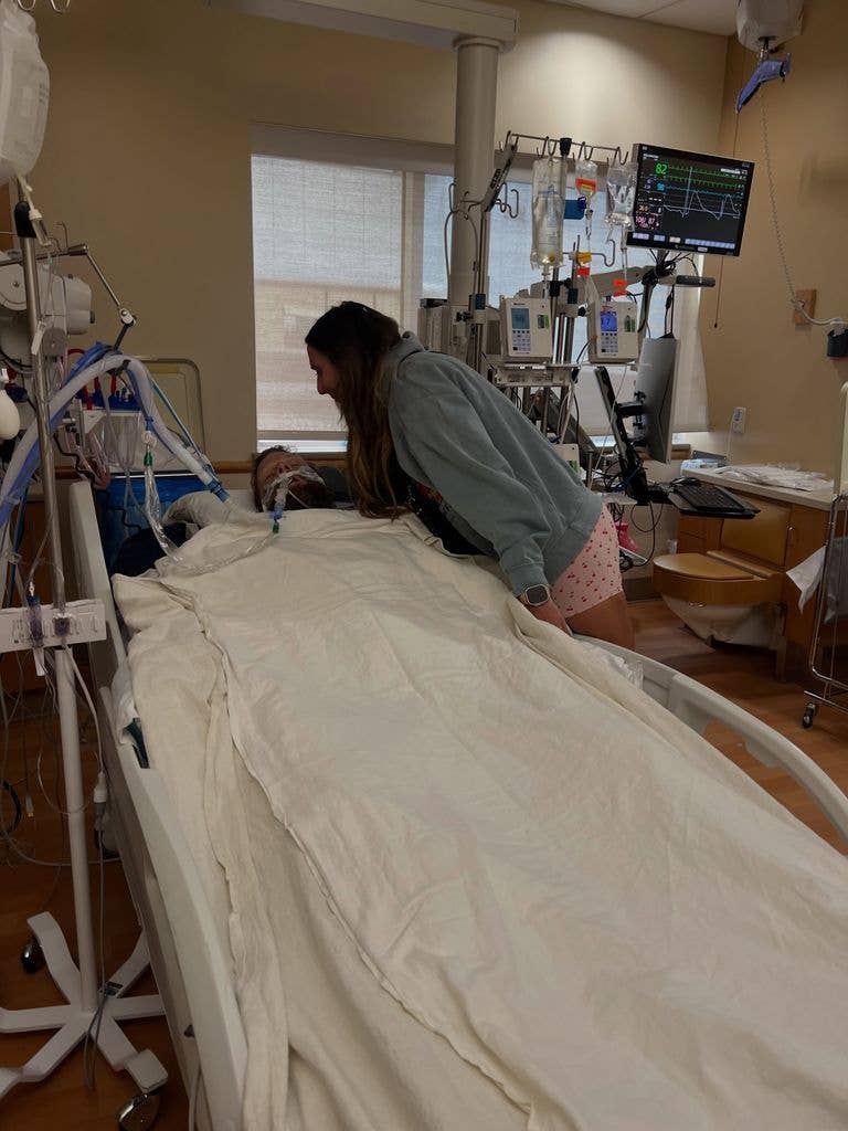 Linsey Devey hovers over husband Jordan Devey as he lies in a hospital bed