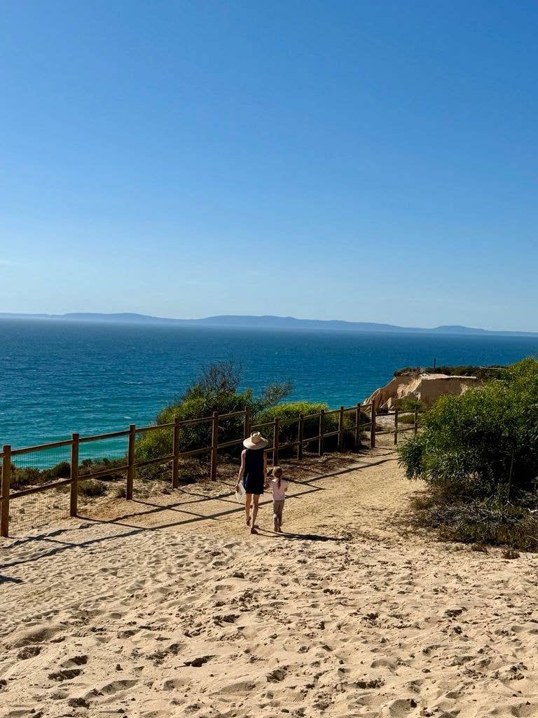 Meghan and Lilibet walking hand-in-hand on the beach