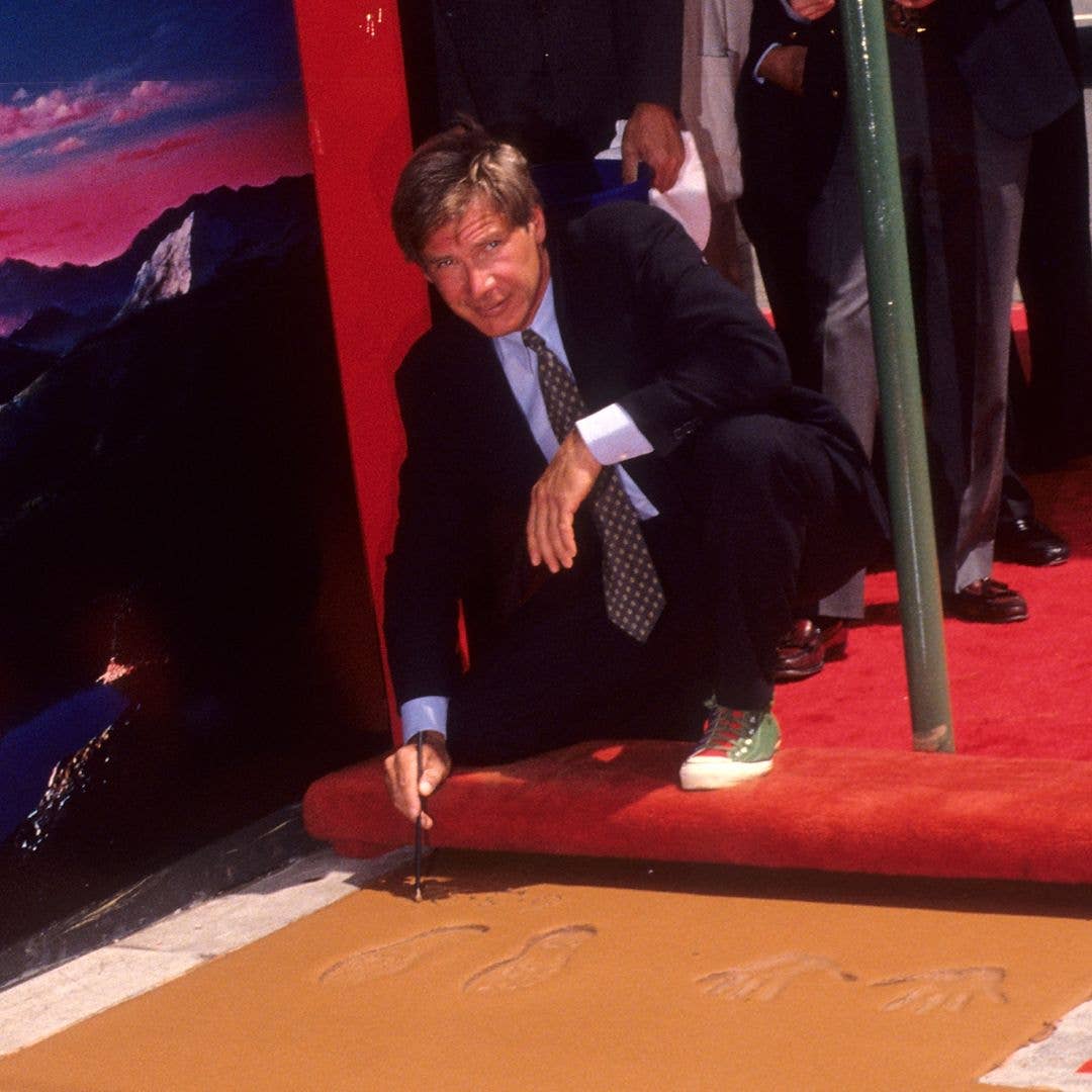 Actor Harrison Ford places his footprints and handprints in cement at the forecourt of the Mann's Chinese Theatre on June 3, 1992 at the Mann's Chinese Theatre in Hollywood, California