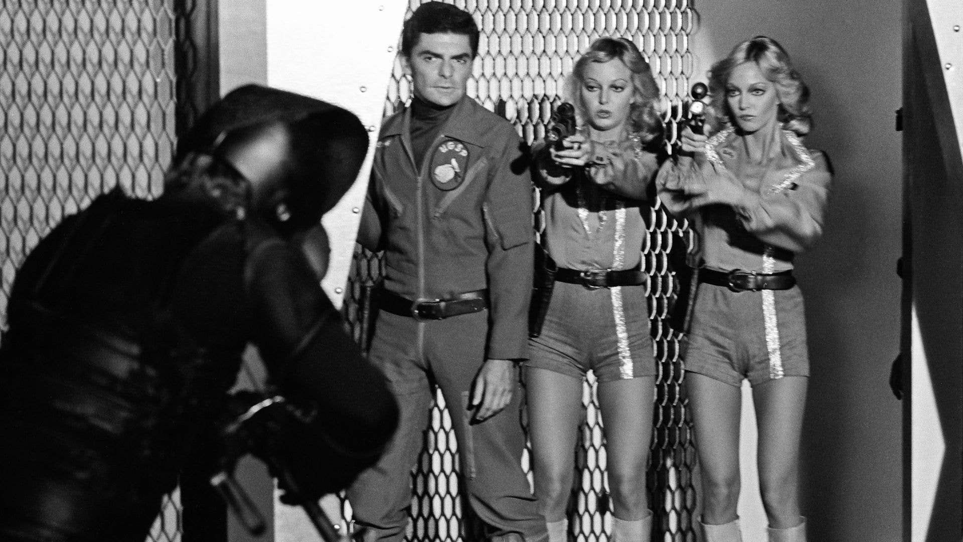 Black-and-white still of Richard Benjamin, Cyb Barnstable and Patricia Barnstable in Quark