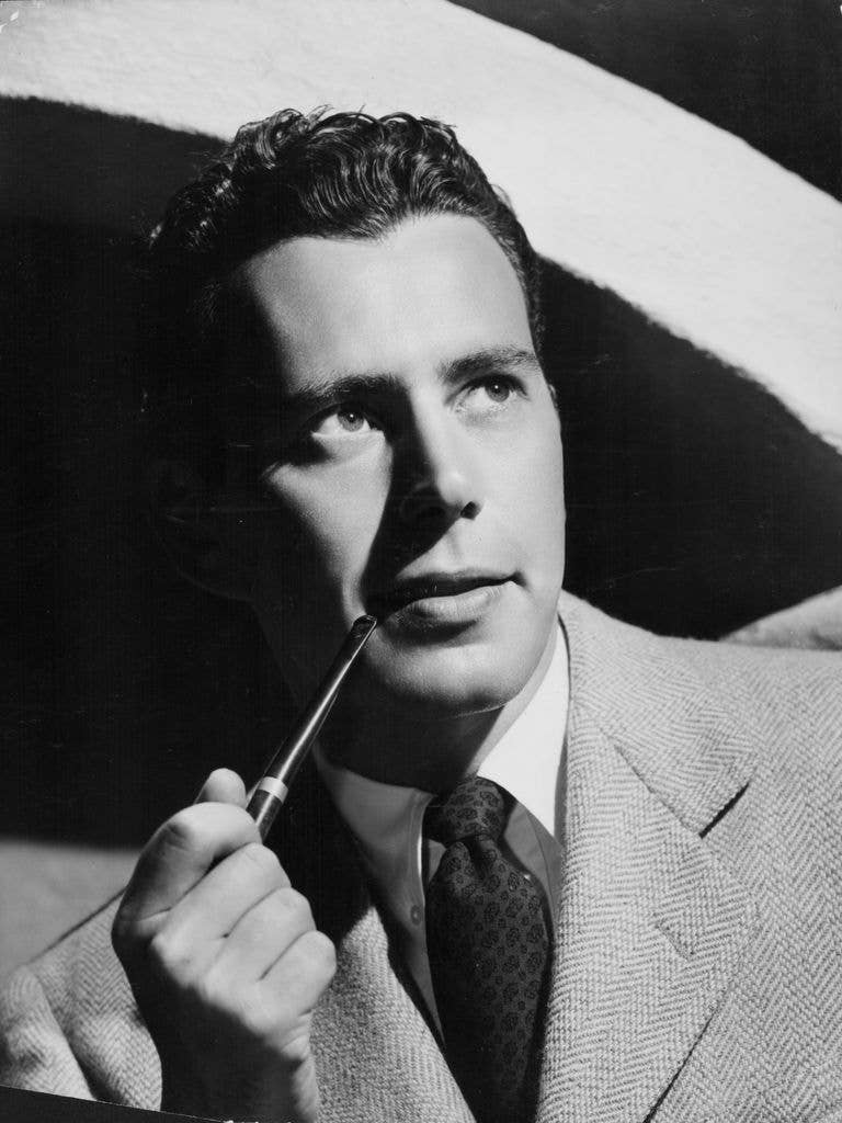 Headshot of actor John Forsythe smoking a pipe, circa 1950.
