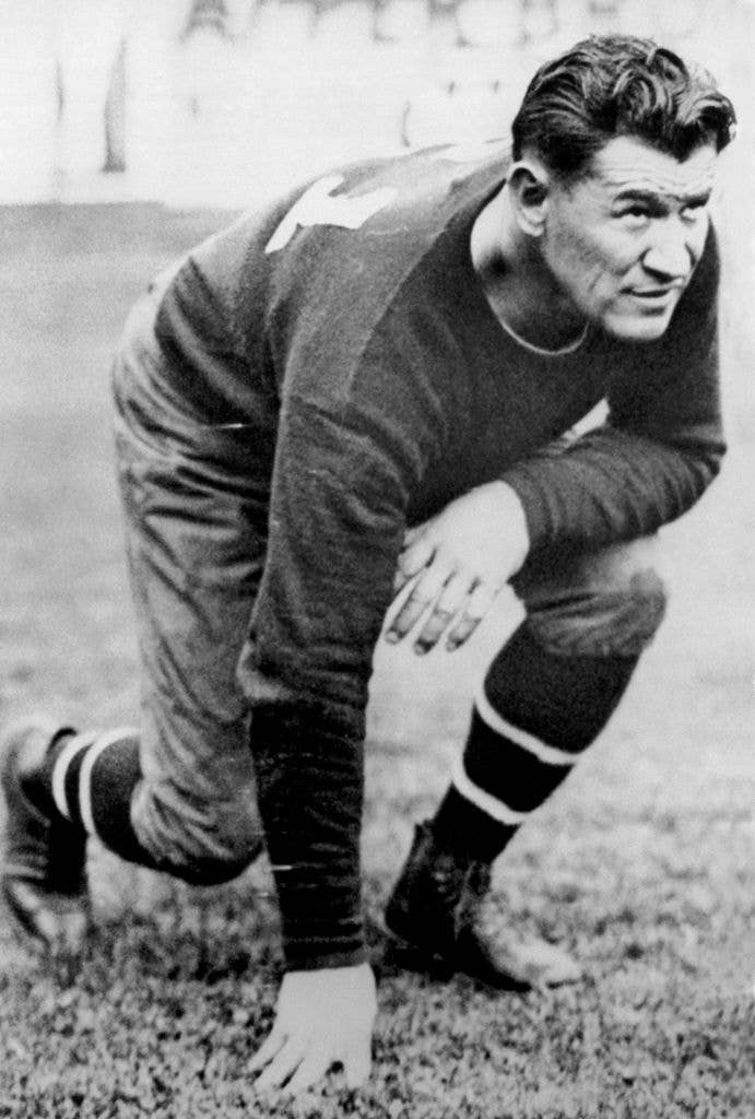 Hall of Fame football player and all around athlete, Jim Thorpe kneels on the pitch in 1925.