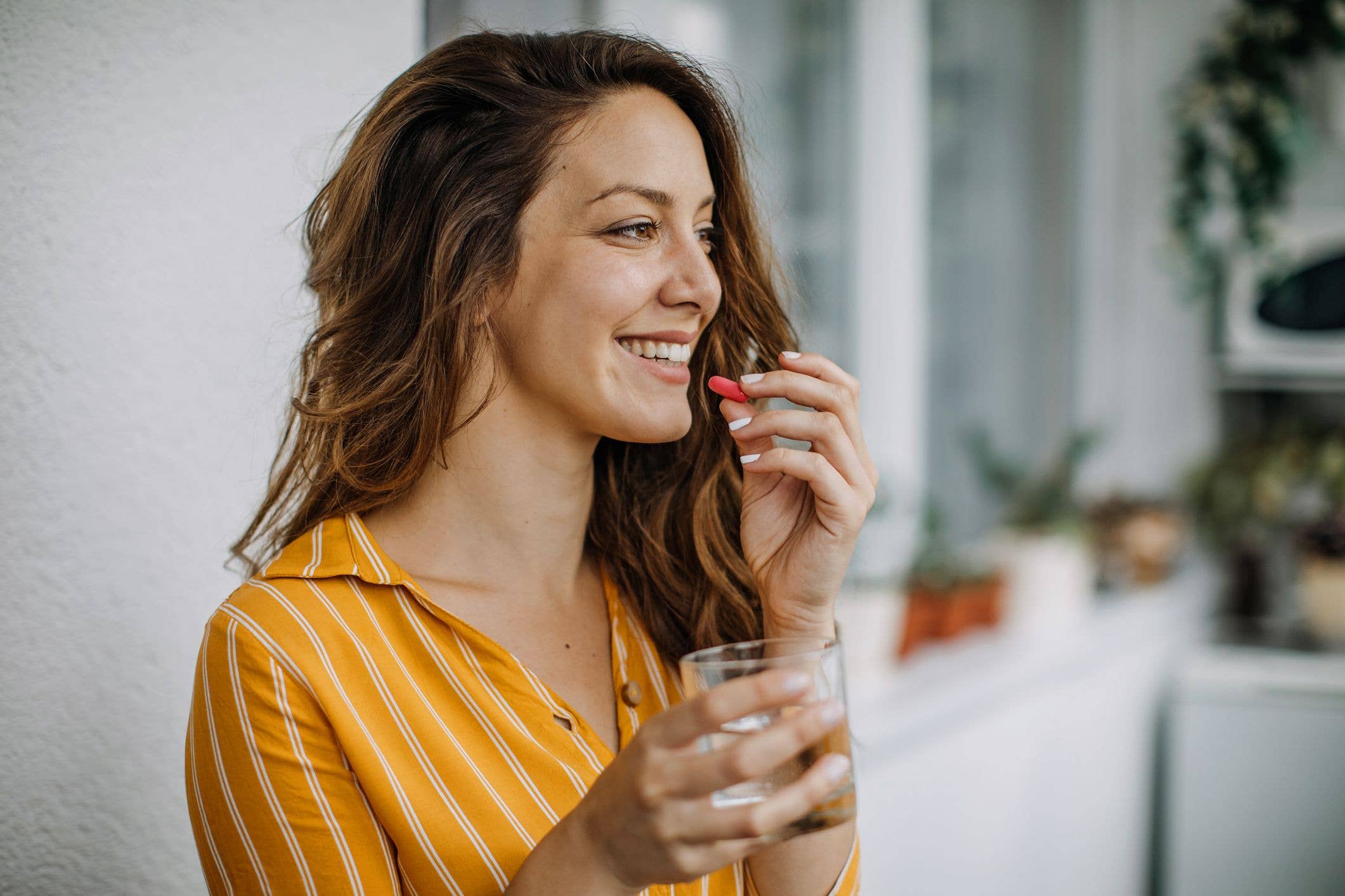 Midlife woman takes supplements at home