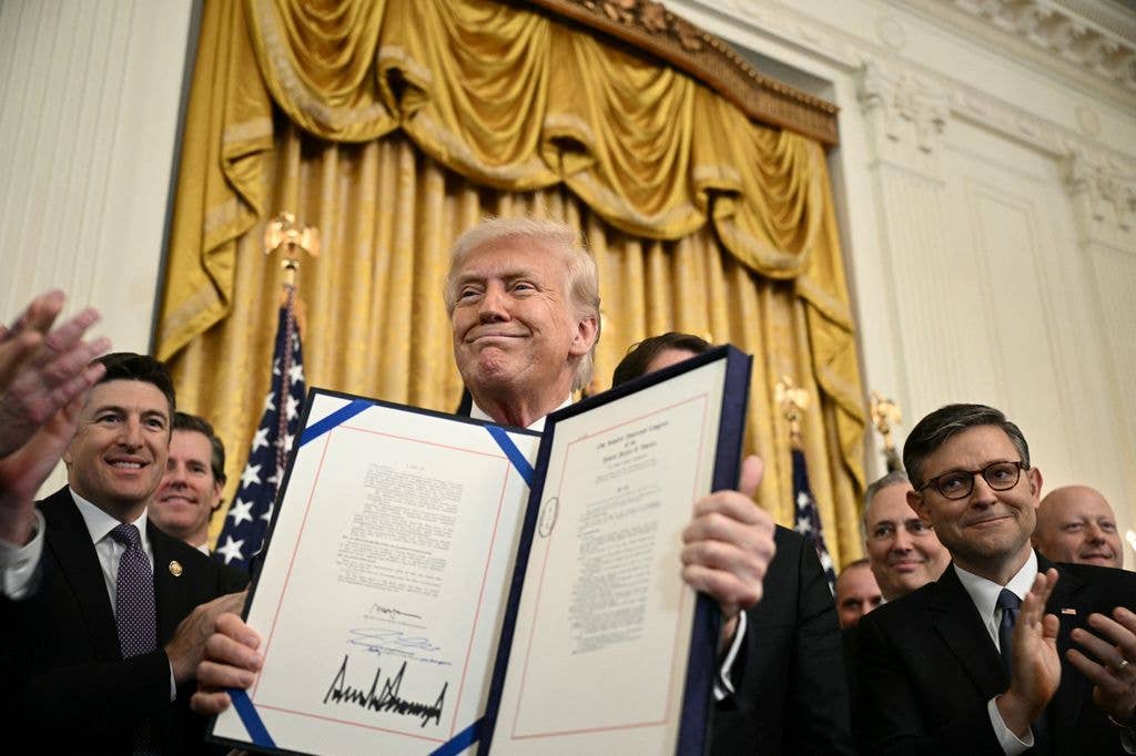 Donald Trump displays the GENIUS Act (Guiding and Establishing National Innovation for US Stablecoins Act), which codifies the use of stablecoins