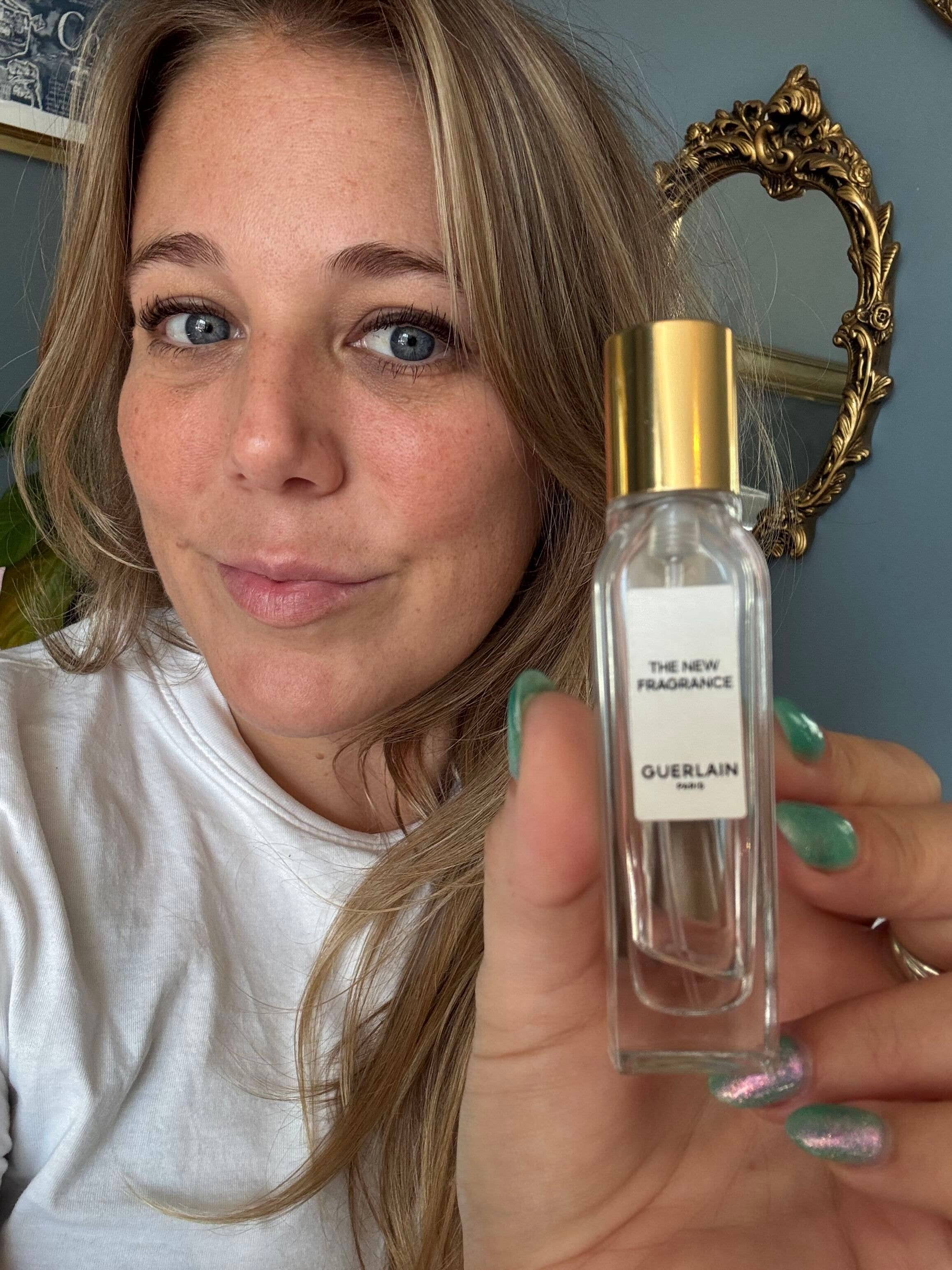 mel posing with a sample size of a fragrance