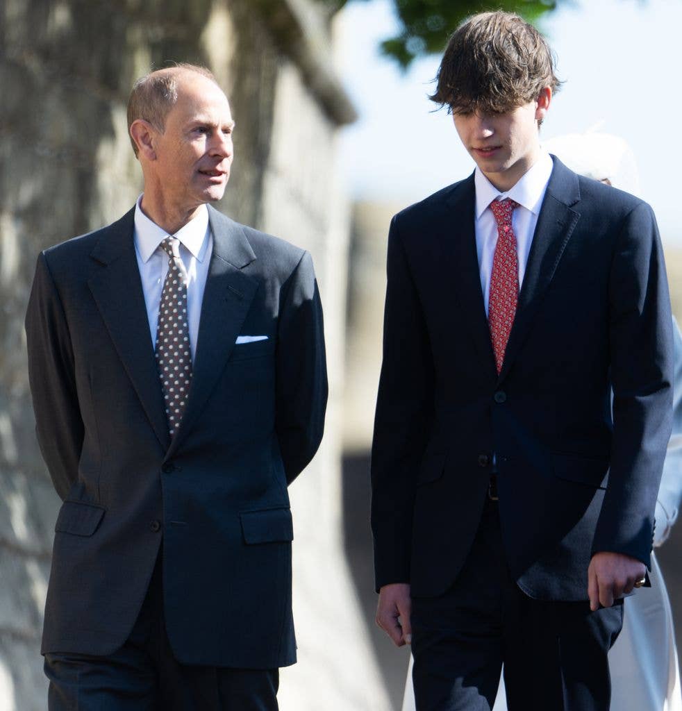Two men in formal suits and ties walking side by side, possibly at an event.