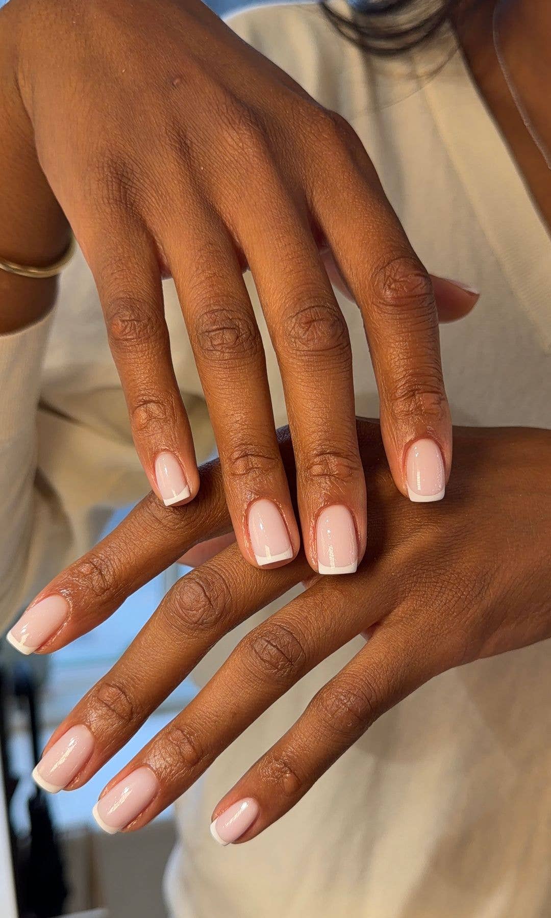 A woman with brown skin showing off an impeccable Ukrabian manicure courtesy of Browchuk