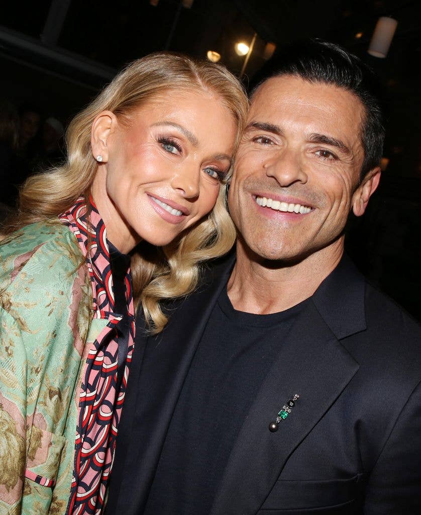photo of kelly ripa leaning into mark consuelos and both smiling