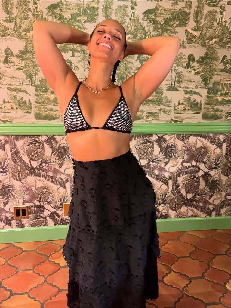 Alicia Keys in a bikini top and black skirt