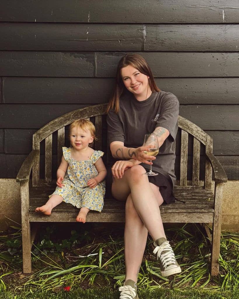 Ireland smiling holding a glass of wine next to her daughter Holland