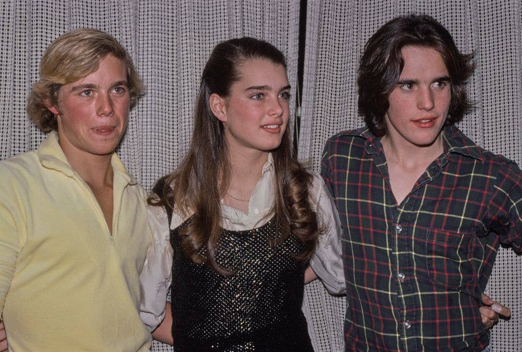 American actor Christopher Atkins, wearing a yellow shirt, American actress Brooke Shields, who wears a black macrame vest over a white shirt, and Matt Dillon, in a plaid shirt, open at the collar, attend an event in New York City, New York, February 1980. Atkins and Shields both starred in 'The Blue Lagoon'.