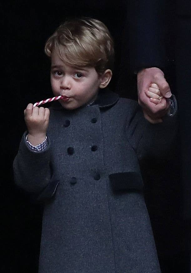 Prince George of Cambridge eats a sweet as he leave following the service at St Mark's Church on Christmas Day 