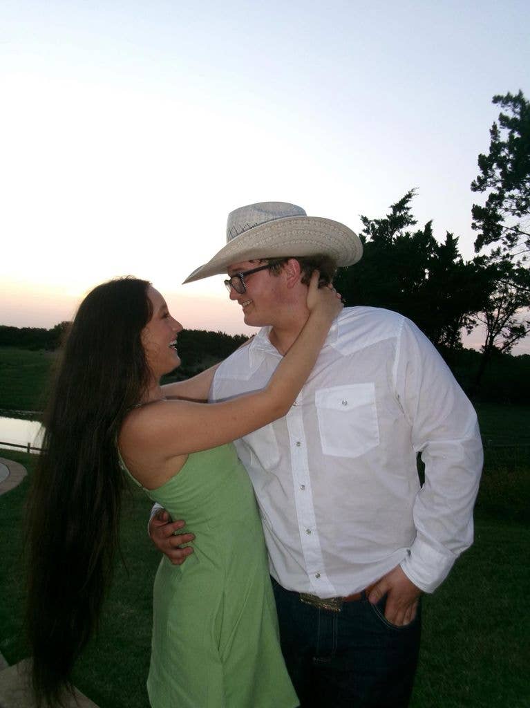Zuma Rossdale wearing a cowboy hat, starring into eyes of girlfriend Theran Rose, whose arms are around his neck